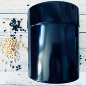 Extra-large black seed storage vault container with vacuum-seal lid and scattered seeds on white wooden surface